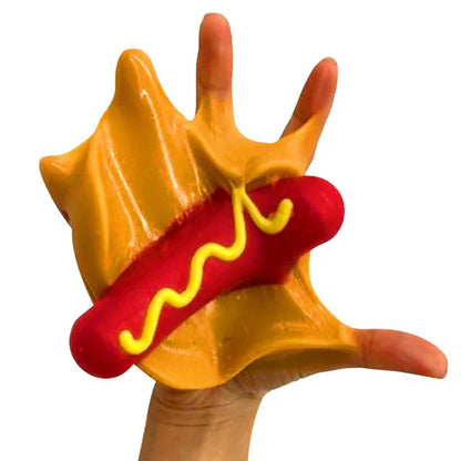 Toy hand with a hot dog and mustard on a white background