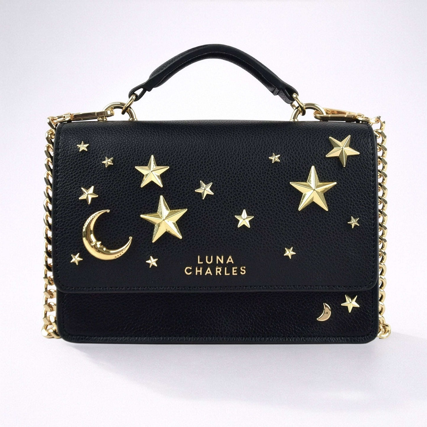 Black handbag with gold stars and moon design on a white background
