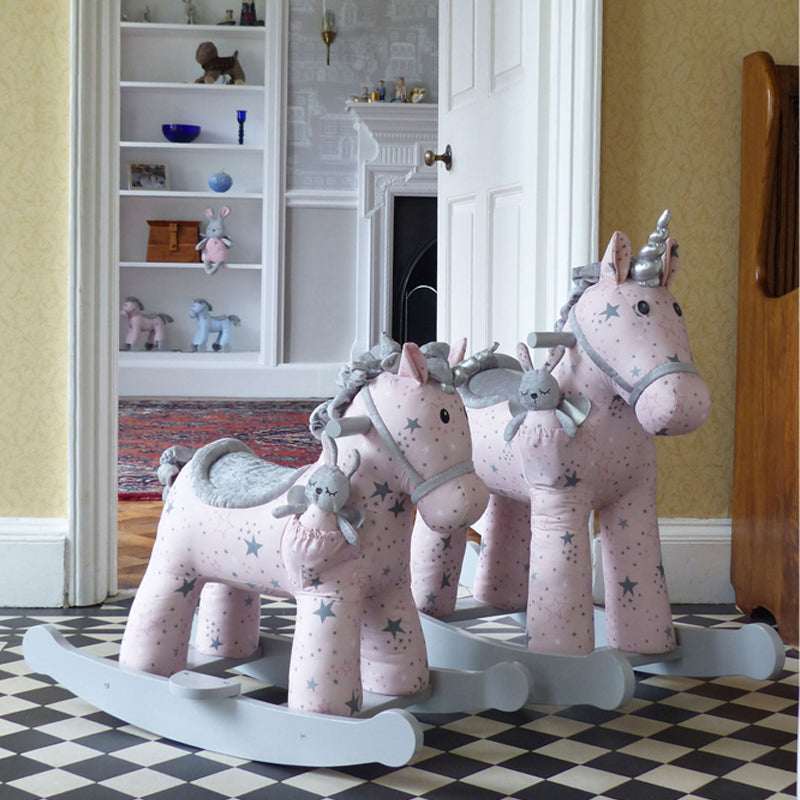 Pink rocking horses with star patterns on a checkered floor.