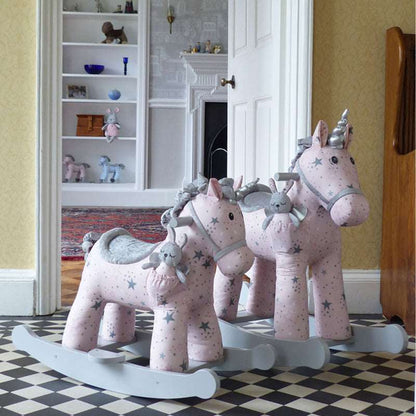 Pink rocking horses with star patterns on a checkered floor.