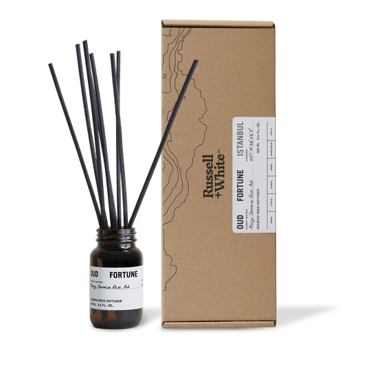 Diffuser bottle with black sticks and cardboard box labeled 'Oud Fortune' by Russell & White on a white background.