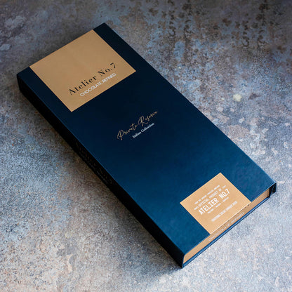 Blue and gold chocolate bar packaging on a textured surface