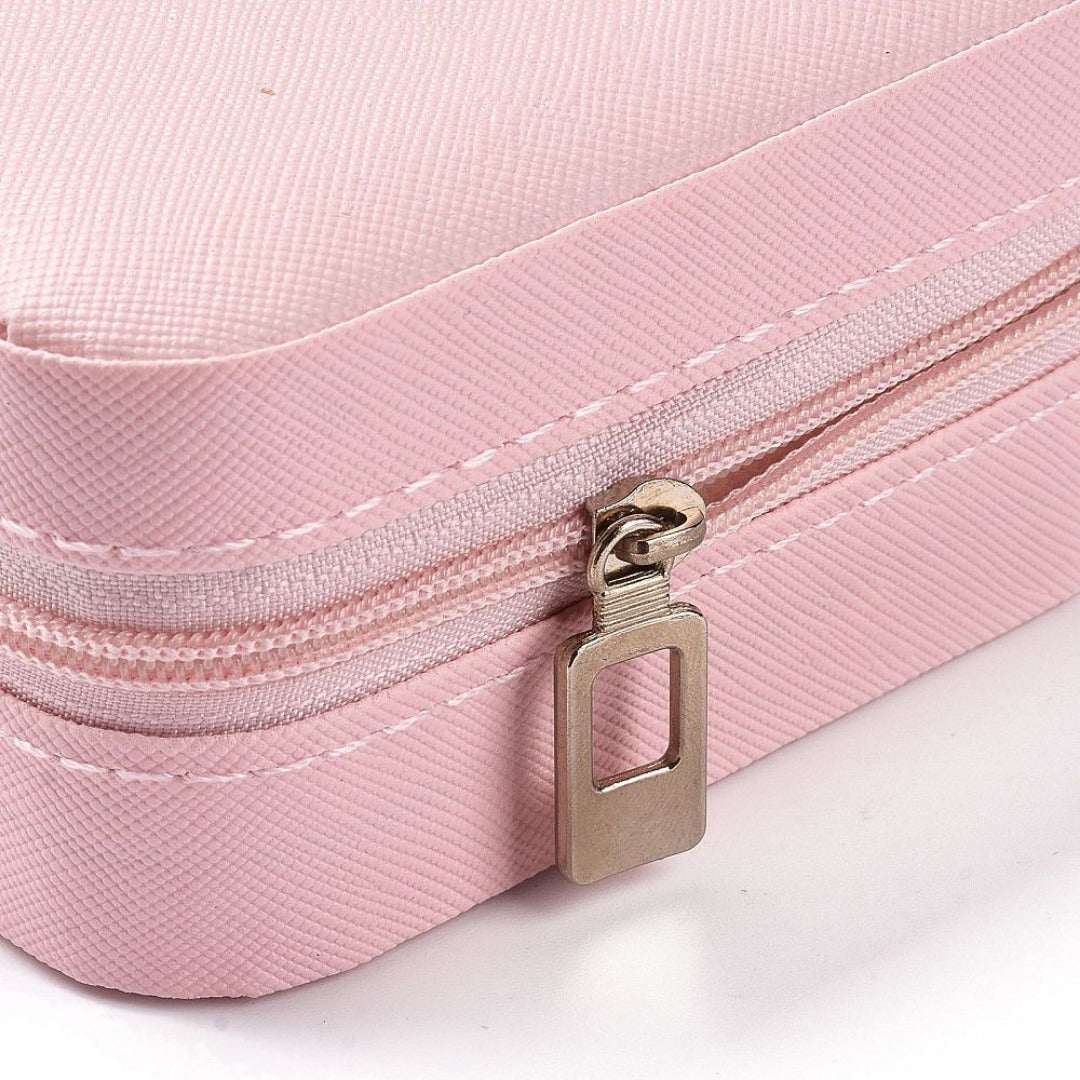 Close-up of a pink zippered pouch with a metal zipper pull on a white background
