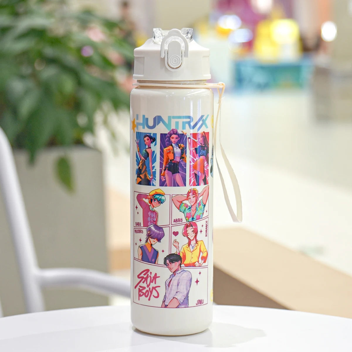 White water bottle with colorful graphics and text on a blurred indoor background
