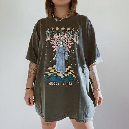 Person wearing a graphic t-shirt with a celestial design and text on a plain background