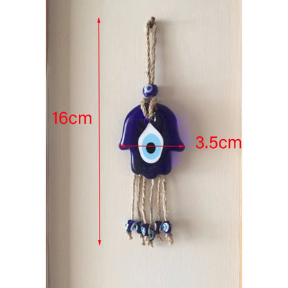 Decorative evil eye charm with measurements on a plain background