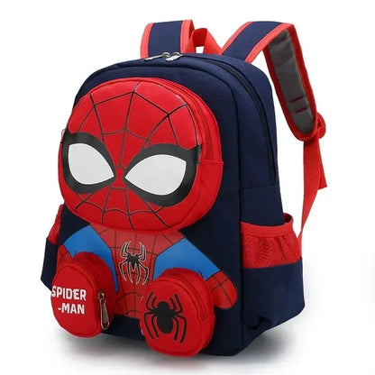 A children's backpack featuring a 3D Spider-Man face design on the front, with red and navy blue colors, white eye details, and a small zippered pouch on the lower left that reads 'SPIDER-MAN'.