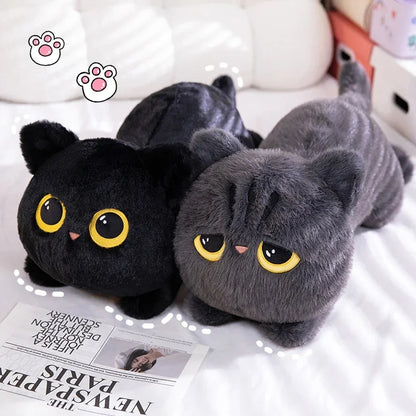 Two plush cat toys, one black and one gray, on a surface with a newspaper underneath.