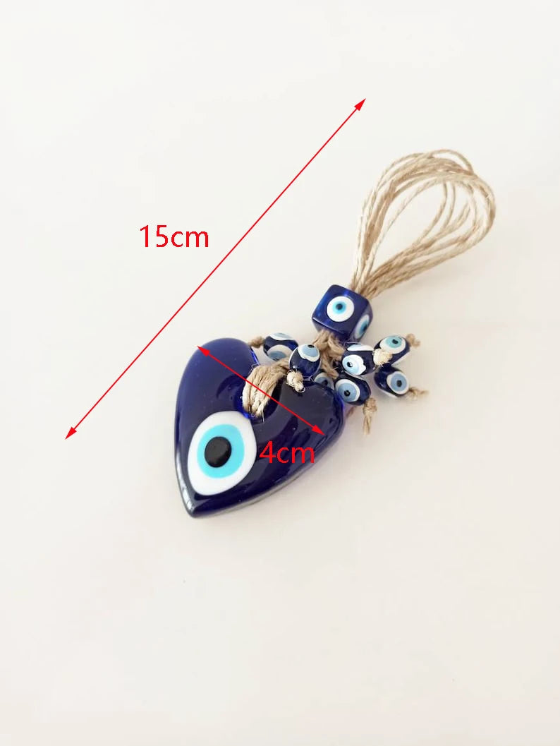 Heart-shaped blue evil eye charm with measurements on a white background