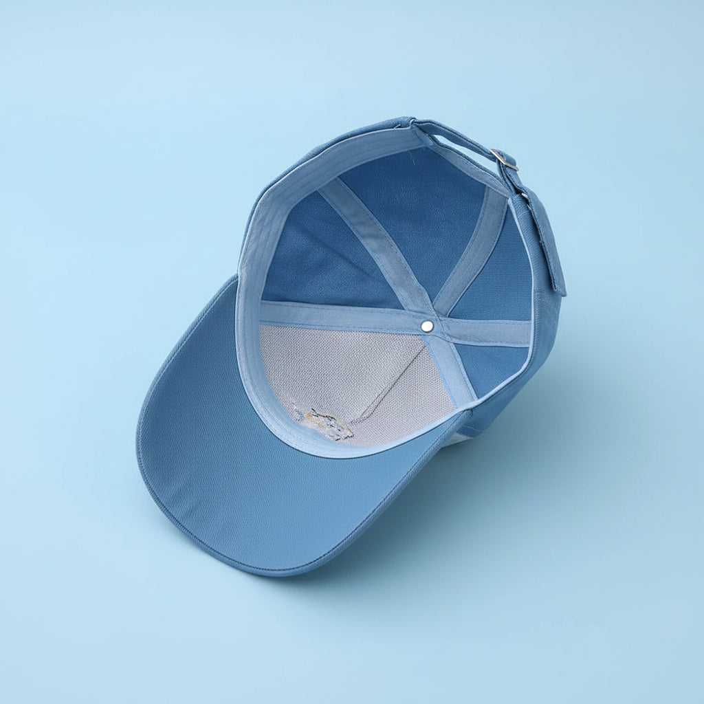 Blue baseball cap with a white interior on a white surface.