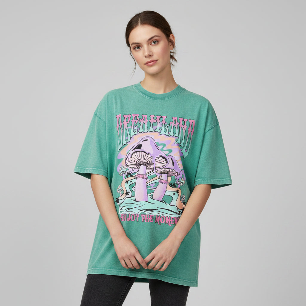 Green t-shirt with mushroom graphic and 'Dreamland Enjoy the Moment' text on a white background