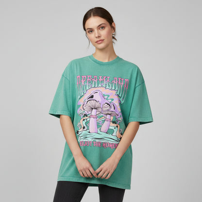Green t-shirt with mushroom graphic and 'Dreamland Enjoy the Moment' text on a white background