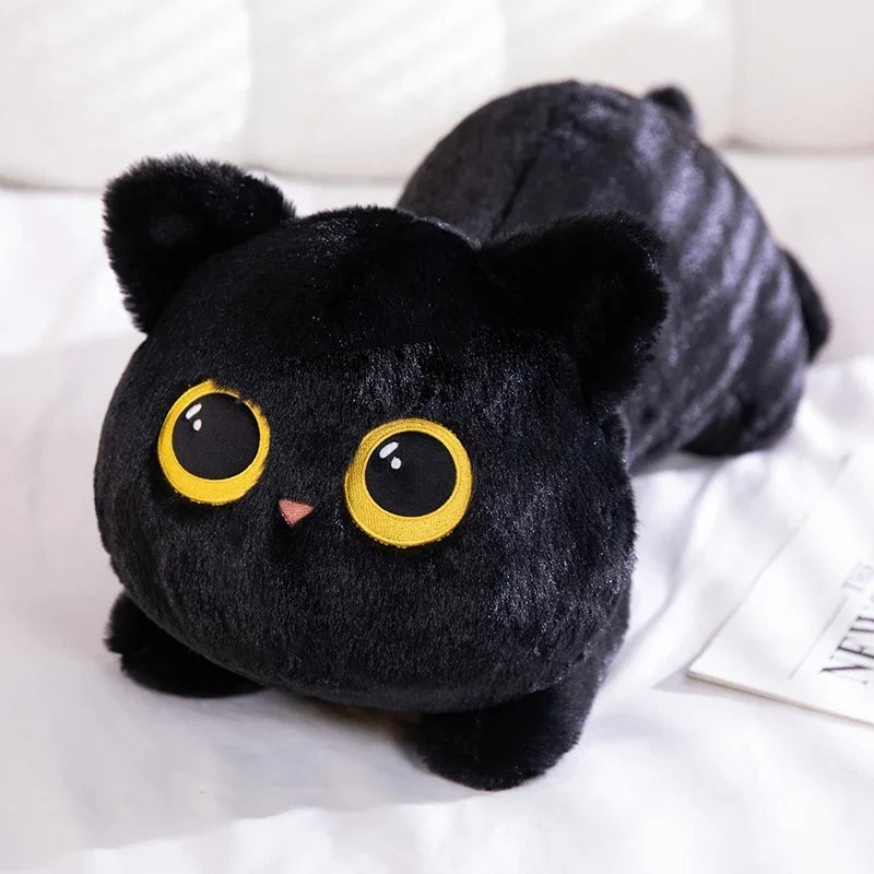 Black cat plush toy with yellow eyes on a white surface