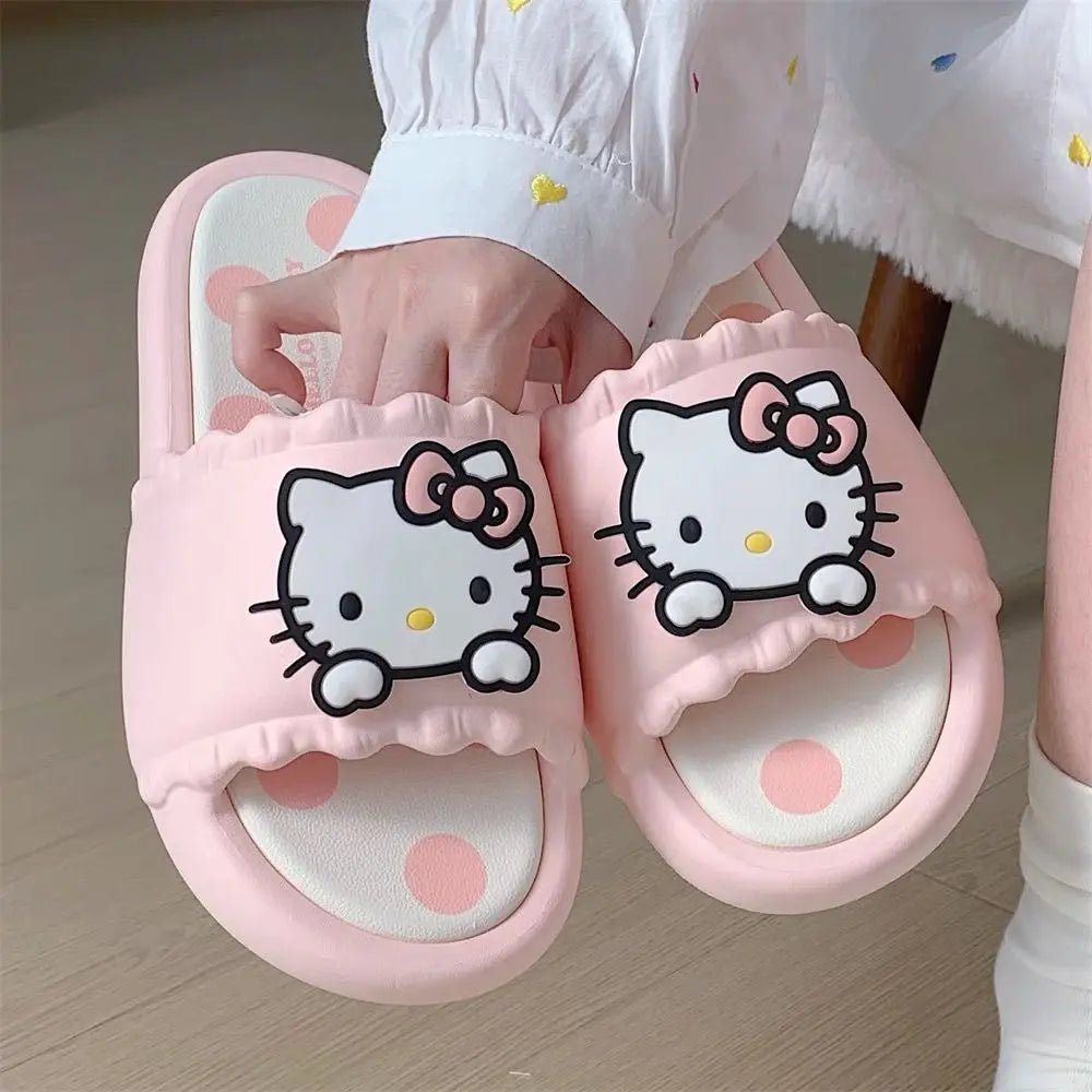 Pink slippers with Hello Kitty design held by a child
