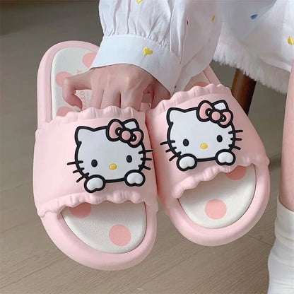 Pink slippers with Hello Kitty design held by a child