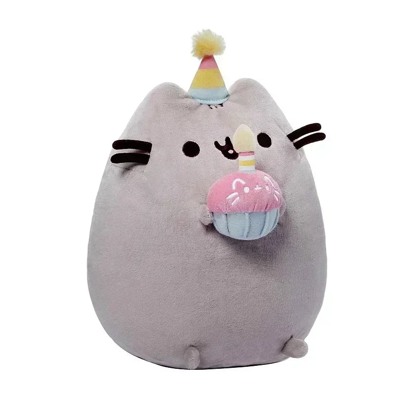 Plush toy resembling a cat with party hat and cupcake decoration on a white background