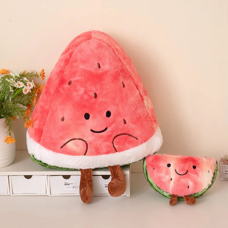 Plush watermelon toy with a smaller version on a shelf with decorative items.