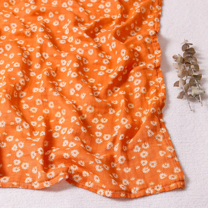 Orange fabric with white floral pattern on a light gray background