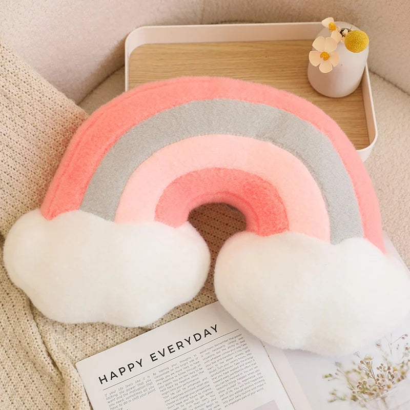 Decorative rainbow pillow with clouds on a magazine