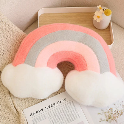 Decorative rainbow pillow with clouds on a magazine