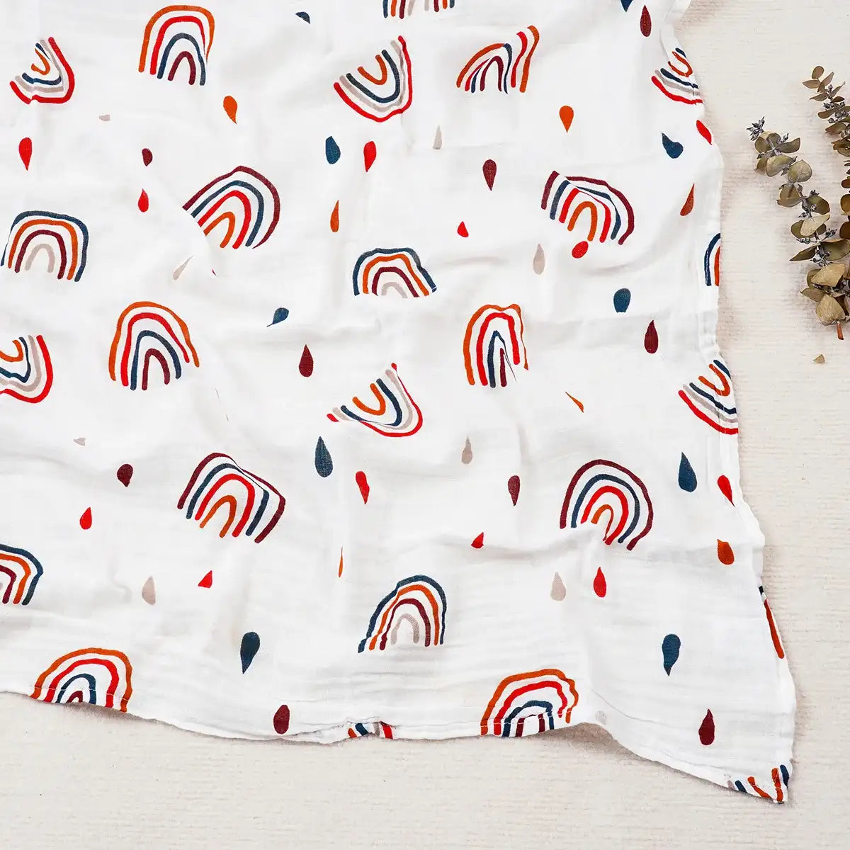 White blanket with colorful rainbow pattern on a light wooden surface