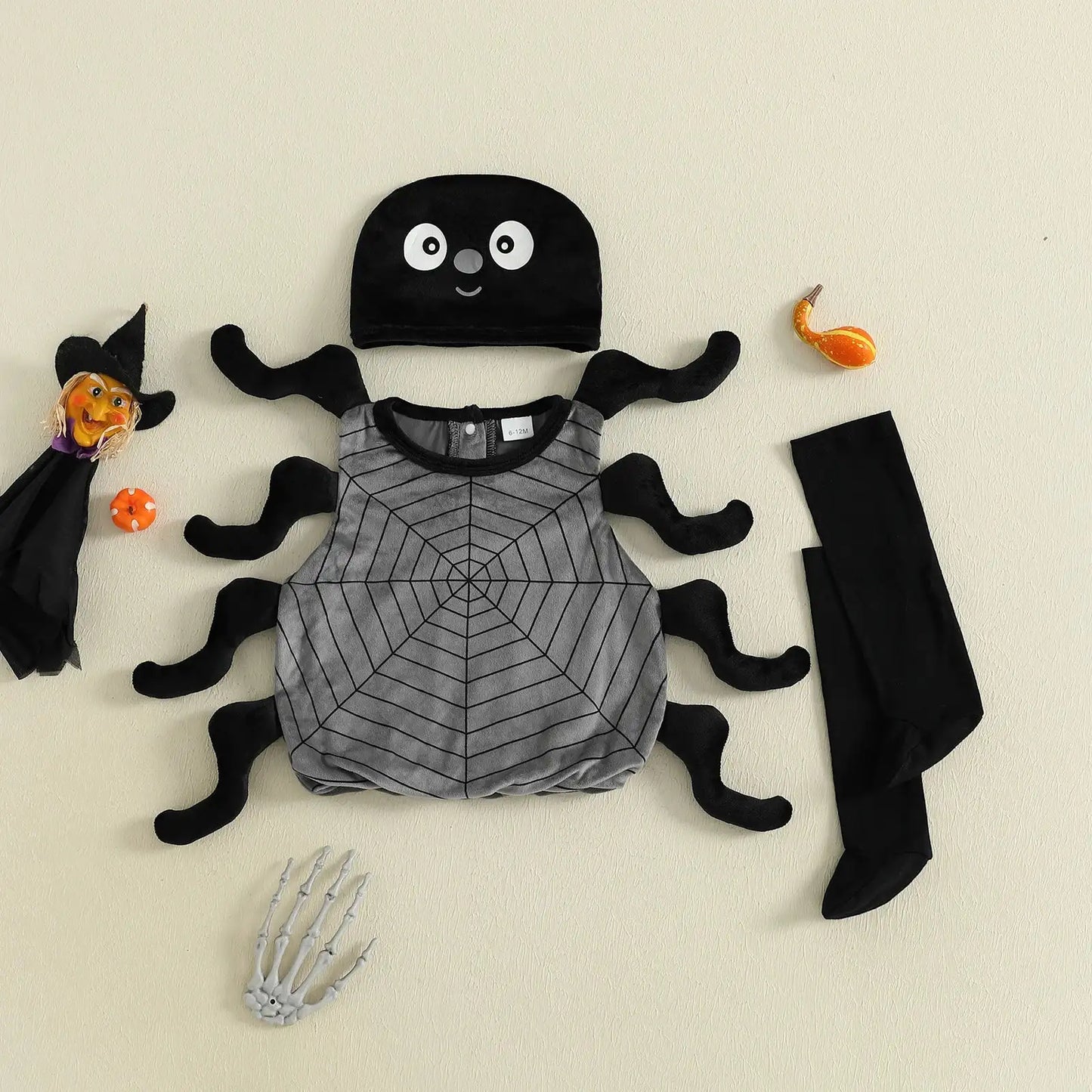 Children's Halloween costume set with spider design on a beige background