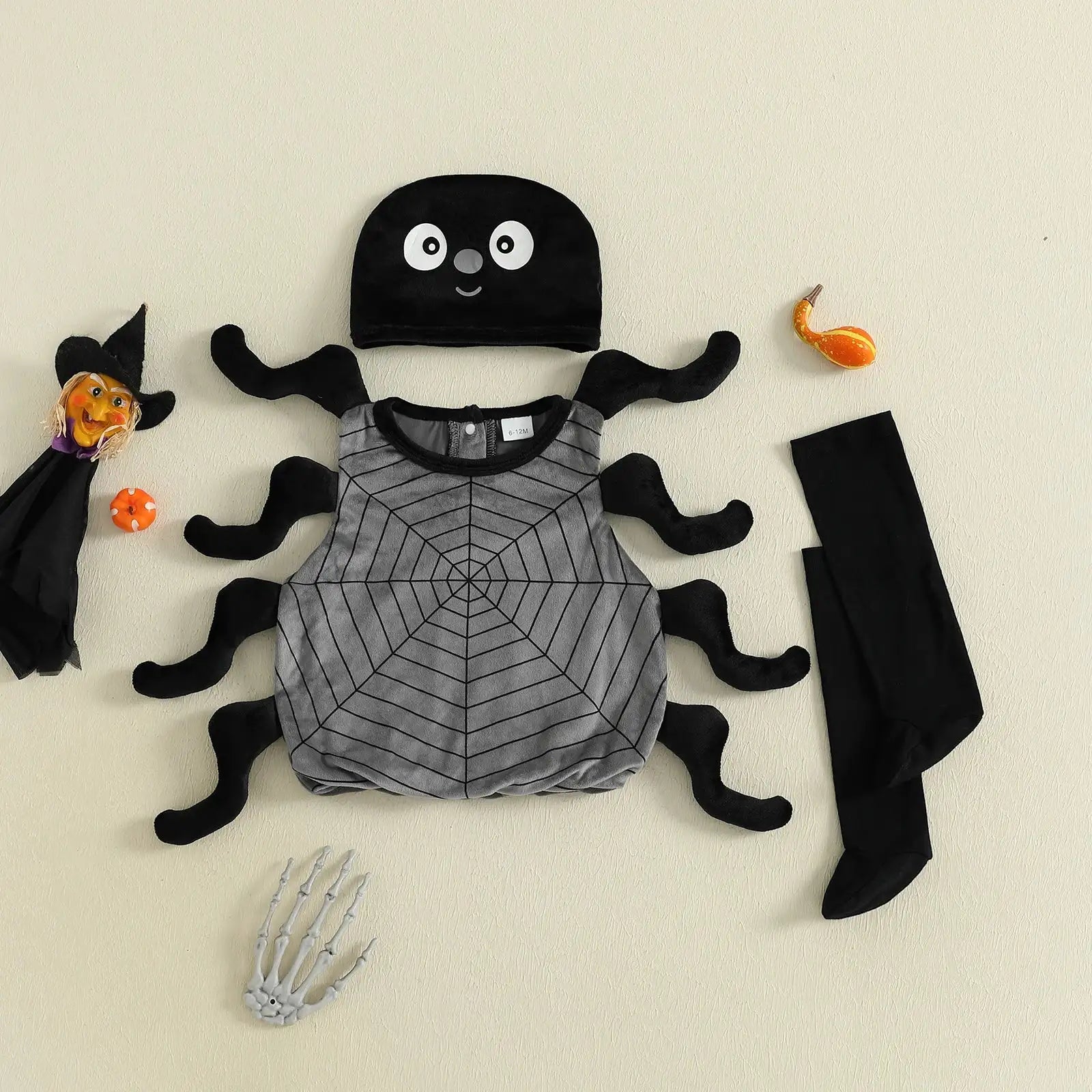 Children's Halloween costume set with spider design on a beige background
