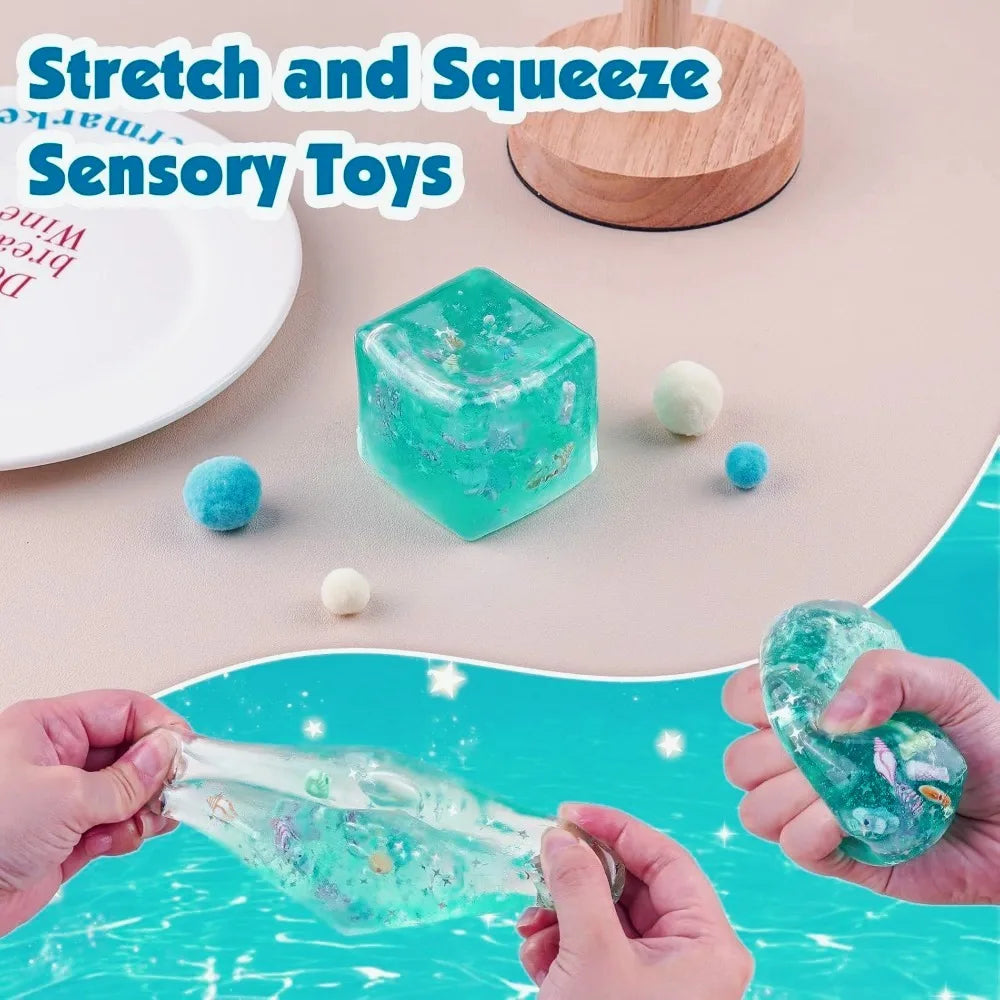 Sensory toys including a blue cube and clear gel-like toy with hands stretching and squeezing them on a light background.