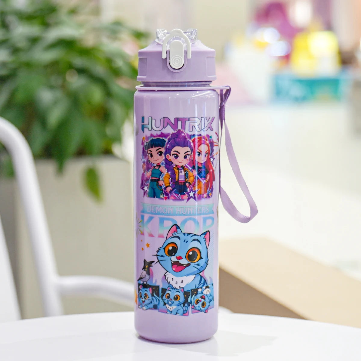 Purple water bottle with cartoon characters on a table