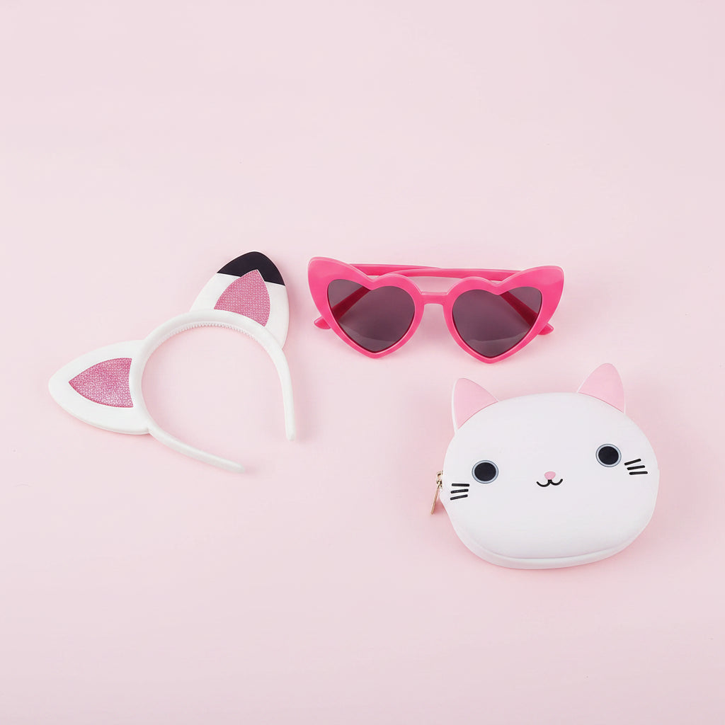 Cat-themed hairband, sunglasses, and coin purse on a pink background