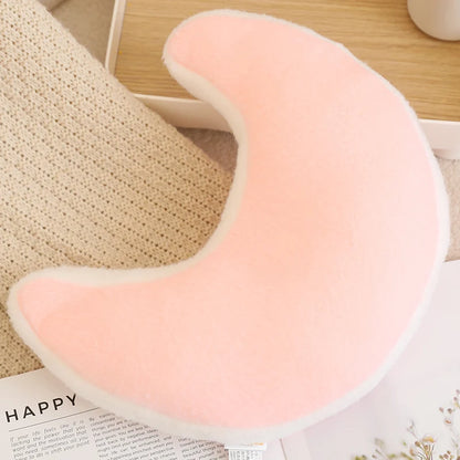 Pink U-shaped pillow on a textured surface with 'HAPPY' magazine underneath