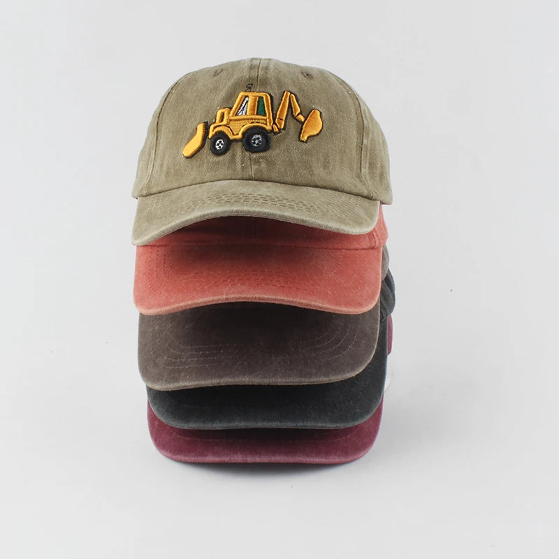 Stack of three baseball caps with a construction vehicle logo on a light gray background