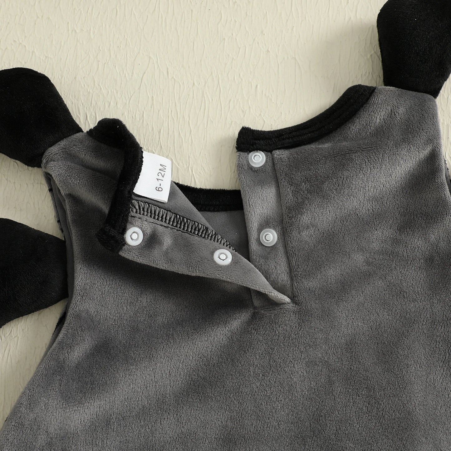 Gray baby romper with black sleeves on a light background
