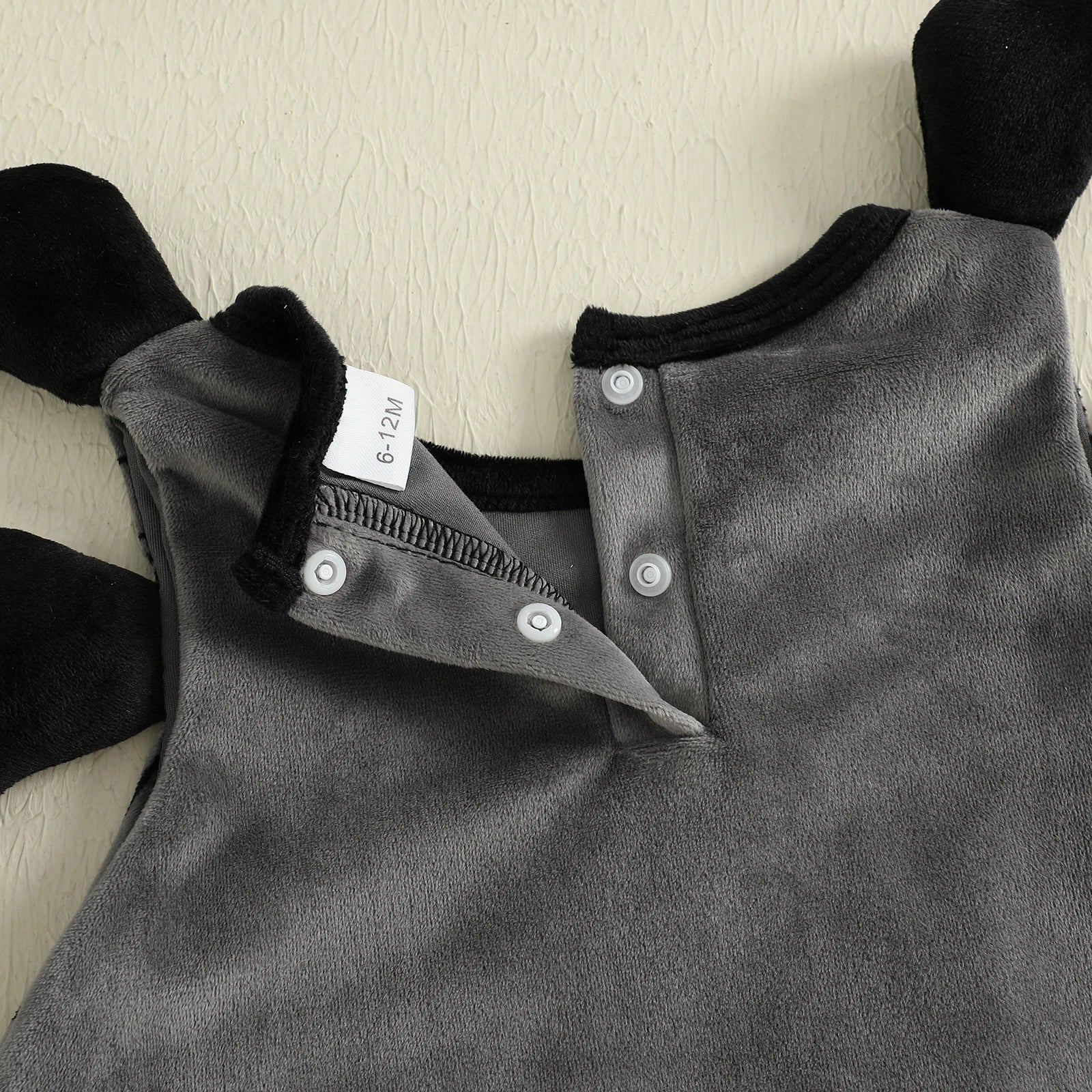 Gray baby romper with black sleeves on a light background