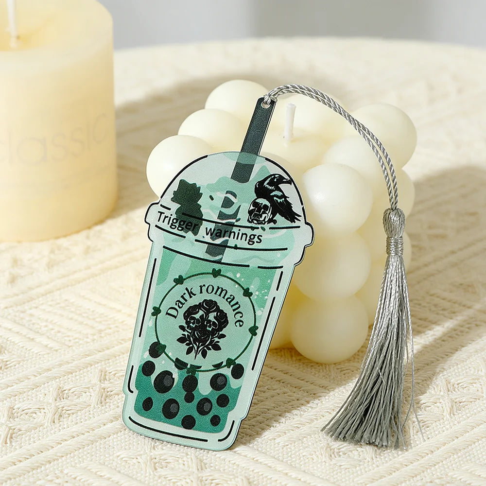 Decorative keychain shaped like a green bubble tea cup with tassel on a textured surface.