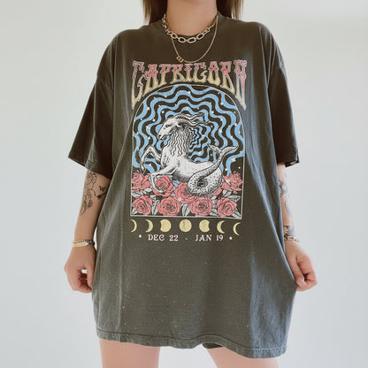 Person wearing a t-shirt with Capricorn zodiac design on a plain background