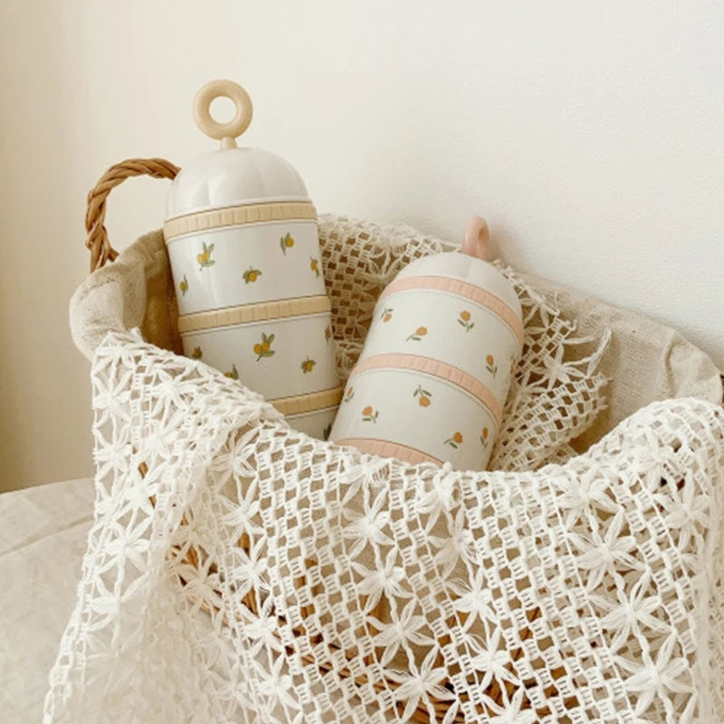 Baby Formula Dispenser Storage Container with floral patterns, placed on a textured surface with a white lace fabric.