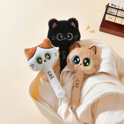 Cat-shaped earbuds with a black, orange, and beige design in a white bowl on a beige background.