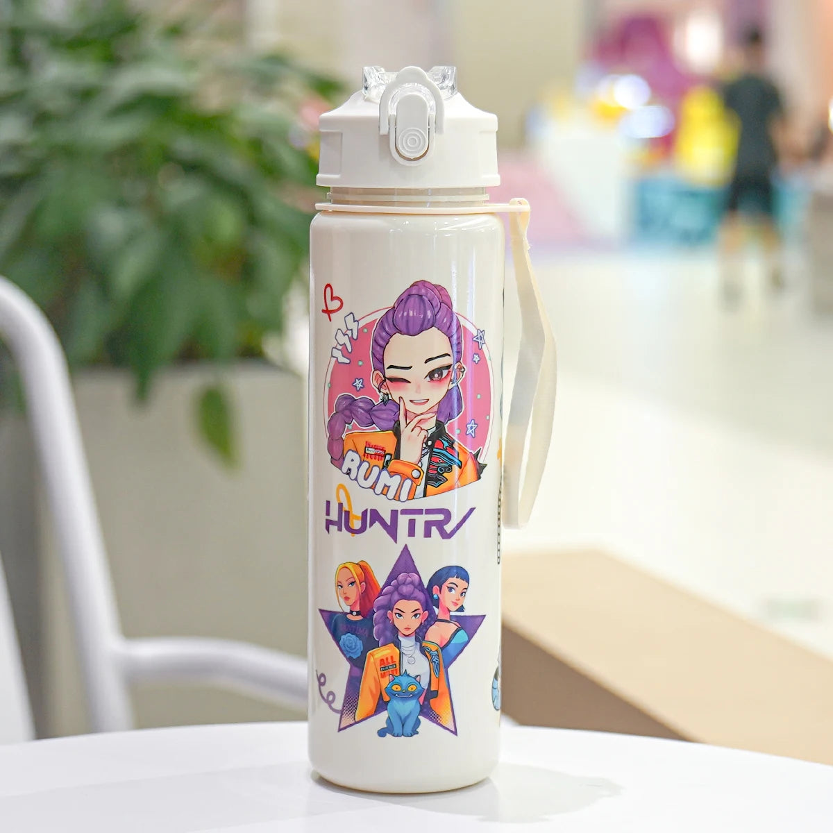Water bottle with colorful design on a table in a blurred indoor setting