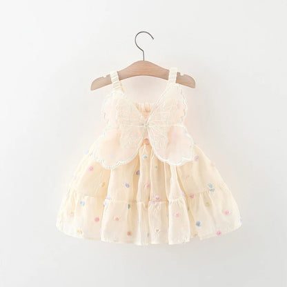 Beige dress with colorful polka dots on a wooden hanger against a white background