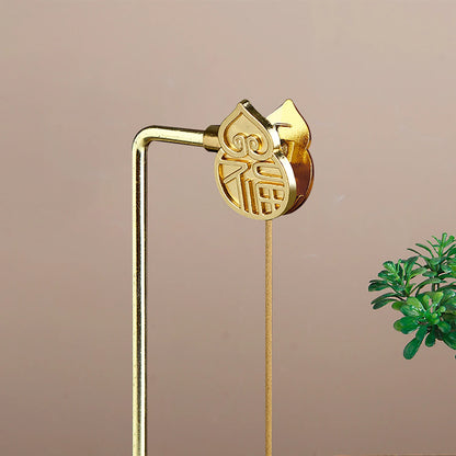 Gold hairpin with a heart-shaped design on a beige background