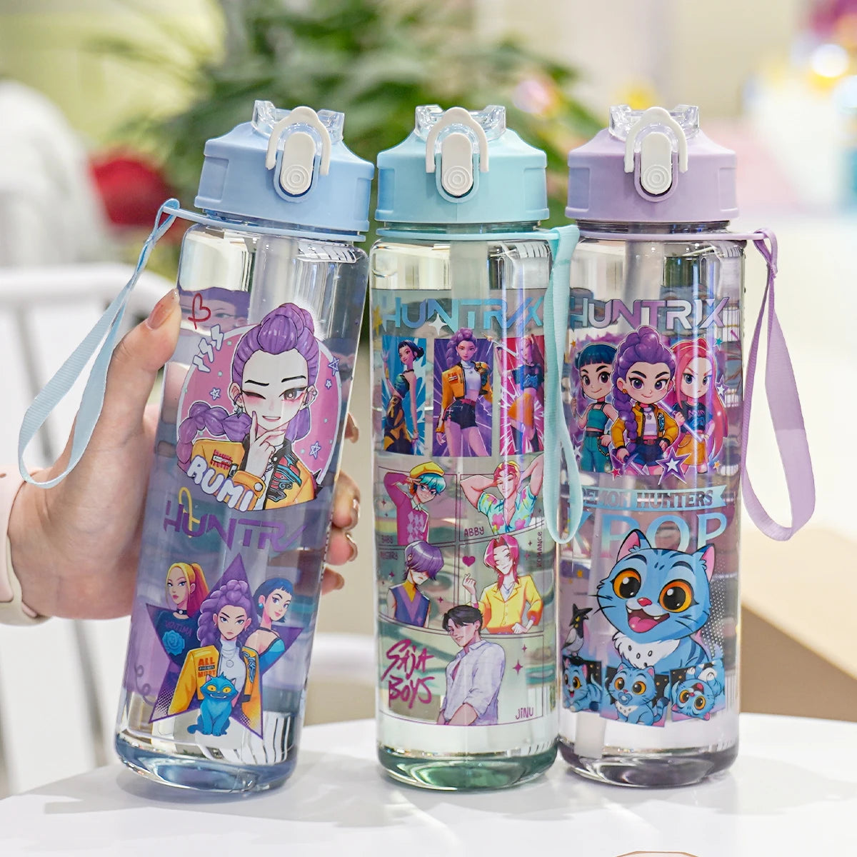 Three water bottles with colorful designs on a table