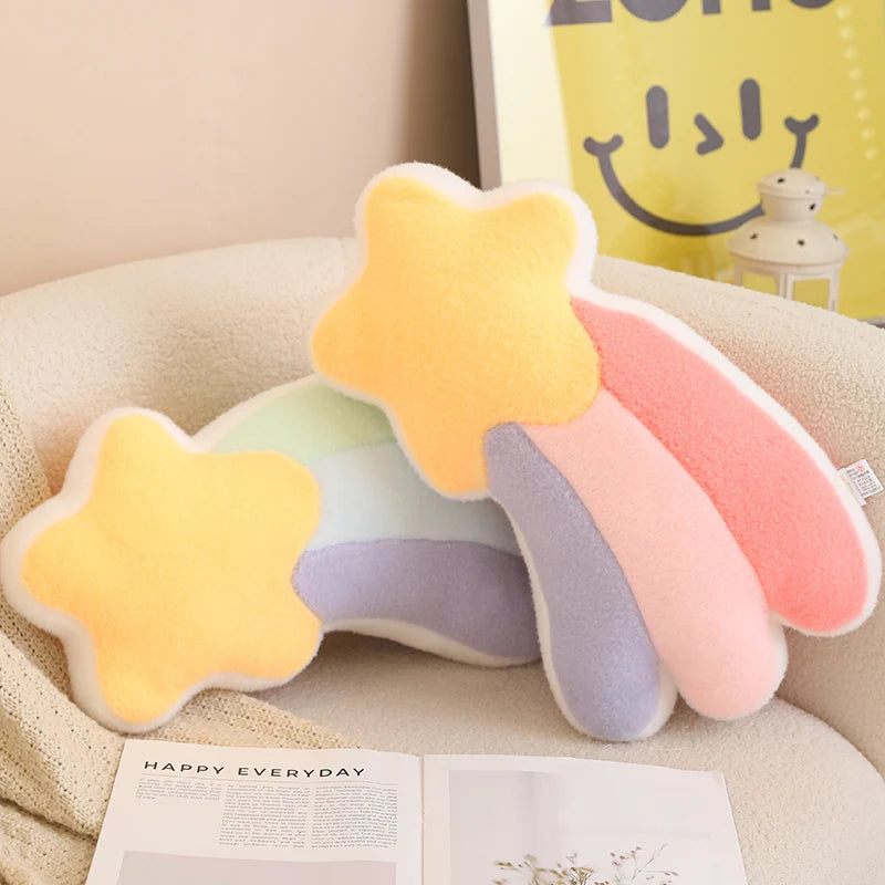 Colorful star-shaped pillow on a couch with a smiley face pillow in the background.