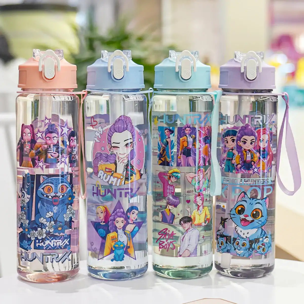 Four colorful water bottles with cartoon character designs on a white surface.