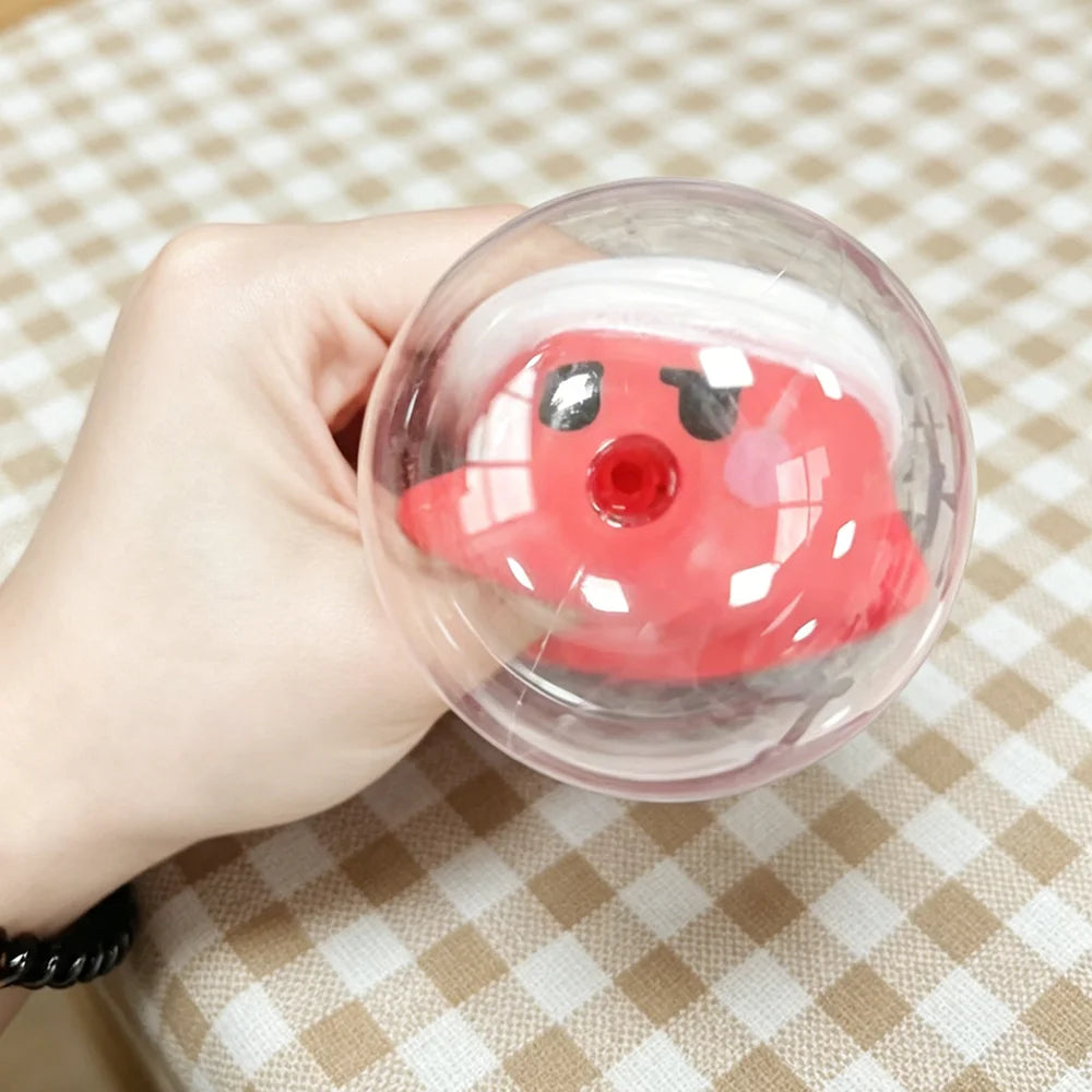 Hand holding a transparent ball with a red character inside on a checkered tablecloth.