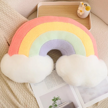 Colorful rainbow-shaped pillow on a couch with a tray and decorative items in the background.
