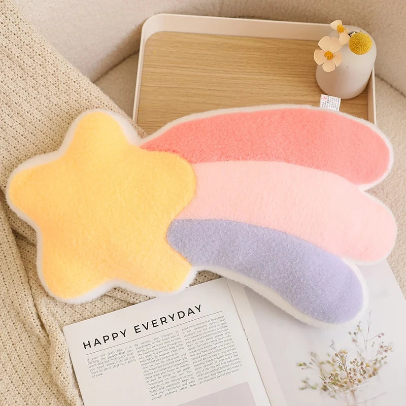 Star-shaped cushions in pastel colors on a table with a magazine underneath.