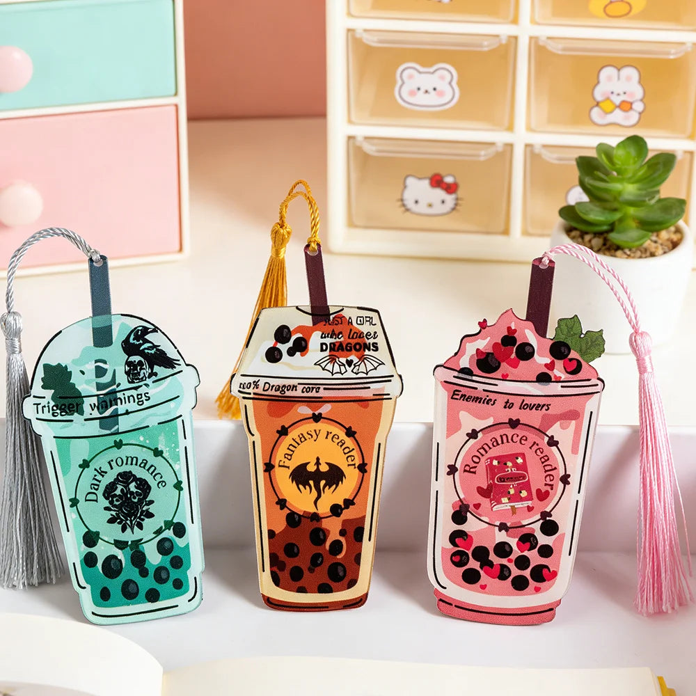 Three bubble tea-shaped bookmarks with tassels on a white surface.