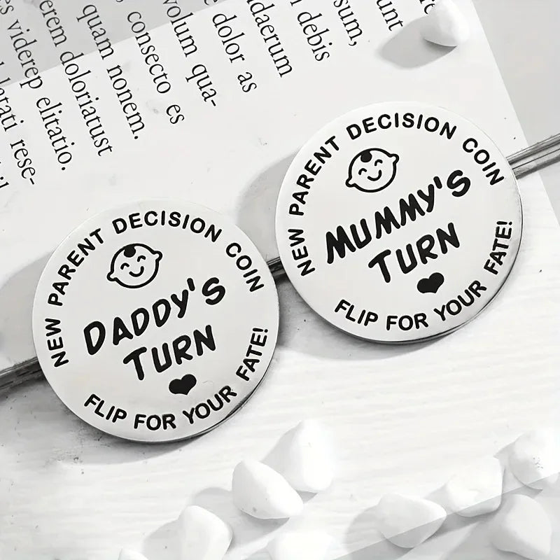 Two round decision coins labeled 'Daddy's Turn' and 'Mummy's Turn' on a white surface with text in the background.