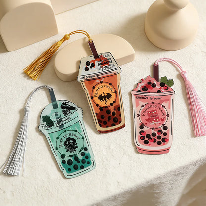 Three bubble tea-themed bookmarks with tassels on a light surface